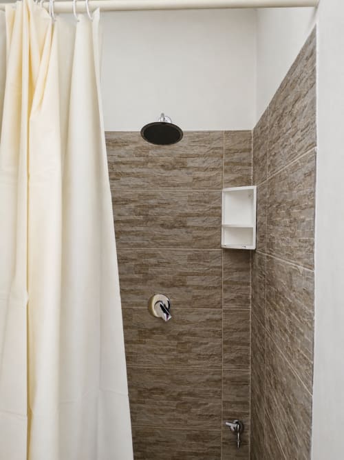 Bagno moderno con pareti in gres effetto legno grigio e soffione pioggia presso Villa Leuka, Noto