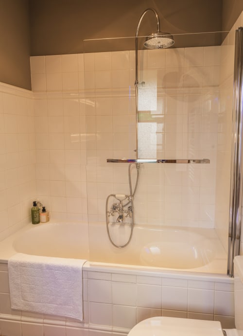 Salle de bain moderne avec douche à l'italienne, pommeau de douche pluie, carreaux blancs métro aux Jardins de