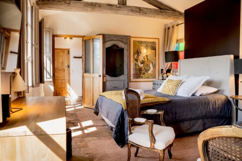 Chambre spacieuse aux Jardins de Baracane à Avignon avec lit king, poutres en bois, décor vintage et vue sur le jardin