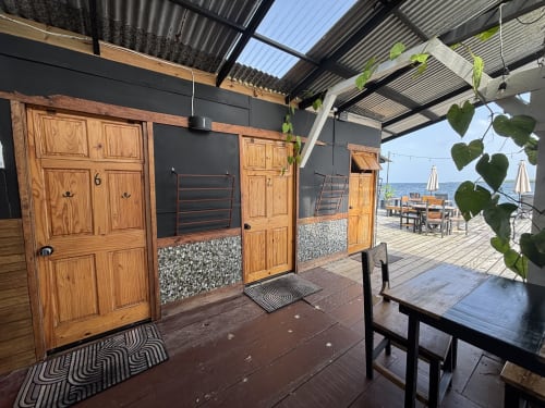 BarrBra BnB overwater cabin in Bocas del Toro with wooden doors, sea view deck, and tropical plants