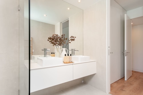 Banheiro moderno com pias duplas, armários brancos e espelho na Villa Prestige Quinta do Pinhao, Charneca da Caparica