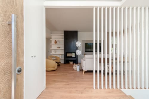 Entrada de villa moderna com piso de madeira, painéis verticais brancos e sala de estar contemporânea com lareira em Republica do