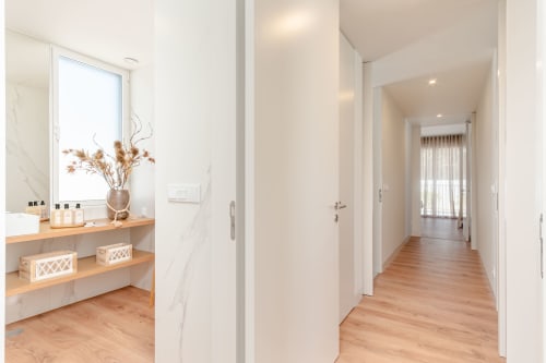 Modern villa hallway with wooden floors, white walls, and bathroom vanity with marble backsplash at Republica do Sul, Aroeira