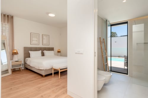 Modern villa bedroom with ensuite bathroom and pool view at Republica do Sul, Charneca da Caparica
