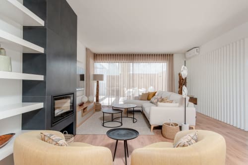 Modern villa living room with cream seating, fireplace, and pool view at Republica do Sul, Aroeira Portugal