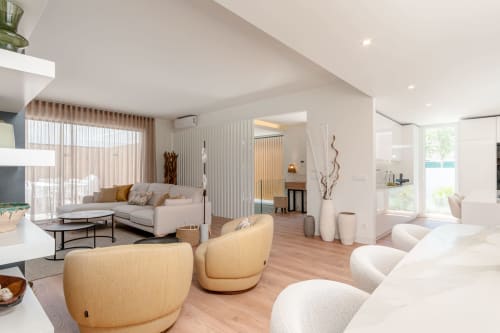 Modern villa living room with cream furnishings, wooden flooring, and pool views at Republica do Sul, Aroeira Portugal