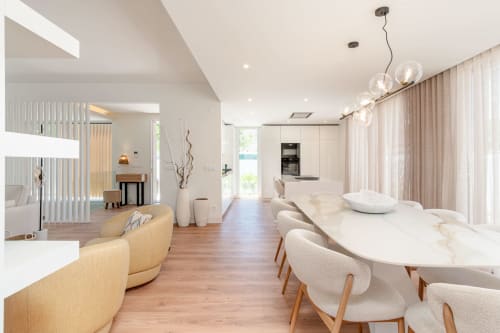 Modern villa dining and living area with pool view, comfortable seating, and contemporary lighting in Aroeira, Portugal