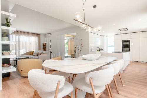 Modern villa dining area with white table, wood chairs, pendant lighting, open-plan kitchen, and lounge at Republica do Sul,