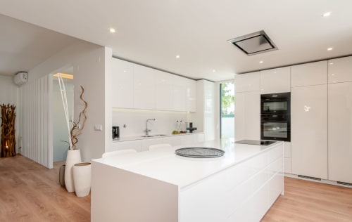 Modern white kitchen with island and dining area in Villa Prestige, Aroeira Portugal
