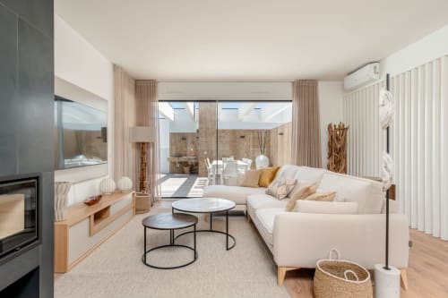 Modern villa living room with cream sofa, fireplace, and glass doors opening to pool view terrace at Republica do Sul,