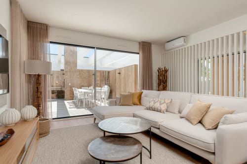 Modern villa living room with cream sectional sofa, marble coffee tables, and terrace view at Republica do Sul, Caparica