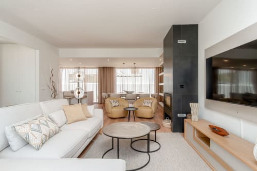 Modern villa living room with white sofa, tan armchairs, fireplace, and TV at Republica do Sul in Charneca da Caparica