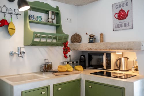 Angolo cucina bianco e verde presso Pietra & Luce B&B a Ostuni con lavello, fornello e scaffali aperti