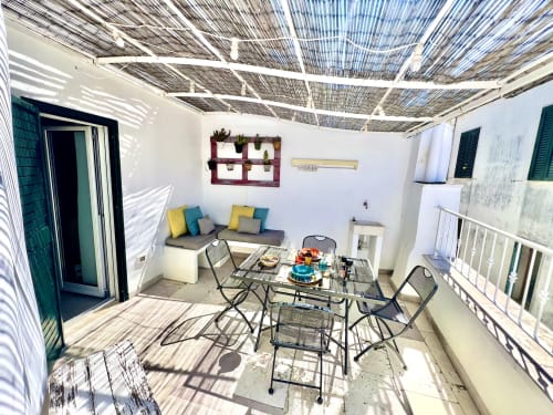 Terrazza luminosa di appartamento in stile Ostuni presso Pietra & Luce con tavolo da pranzo, zona salotto e vista sul mare a Ostuni, Italia