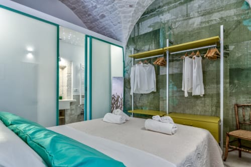 Camera moderna presso Pietra & Luce a Ostuni con letto, appendiabiti giallo e parete d'accento verde