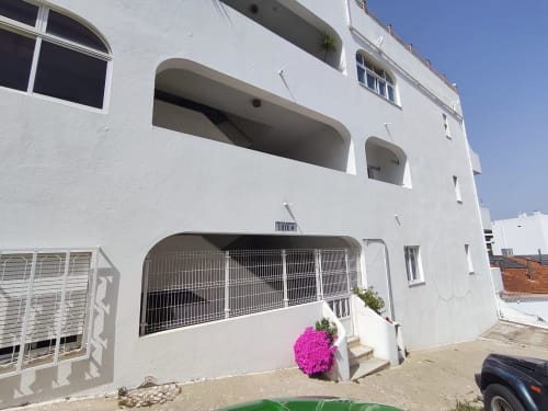 Edifício branco CASA FLOR na Albufeira Inn com flores rosa, hospedagem de dois quartos no centro de Albufeira