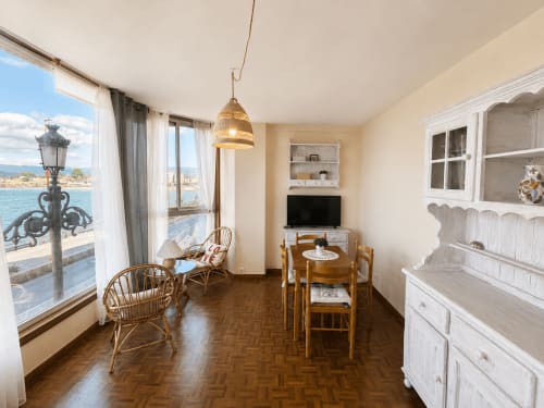 Luminoso apartamento en Baiona con vistas al mar, sillas de mimbre, mesa de comedor de madera y mobiliario blanco