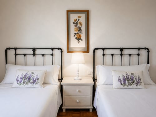 Habitación con cama gemela en el hotel Holibai de Baiona con almohada lavanda y arte floral amarillo