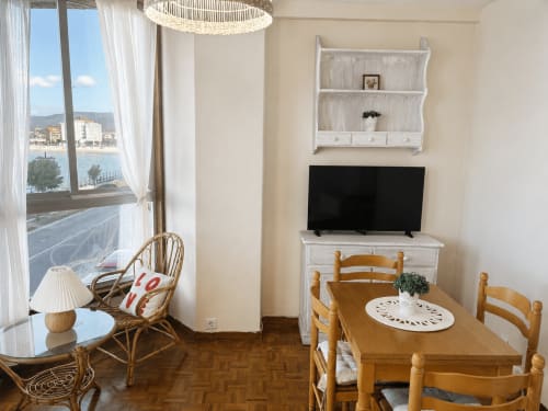 Luminoso apartamento en Baiona con vistas al mar, mesa de comedor de madera, TV y decoración costera en Holibai