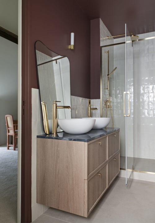 Salle de bain moderne au gîte Le Domaine by A&G à Vendrest avec vasques doubles, robinetterie laiton et murs bordeaux