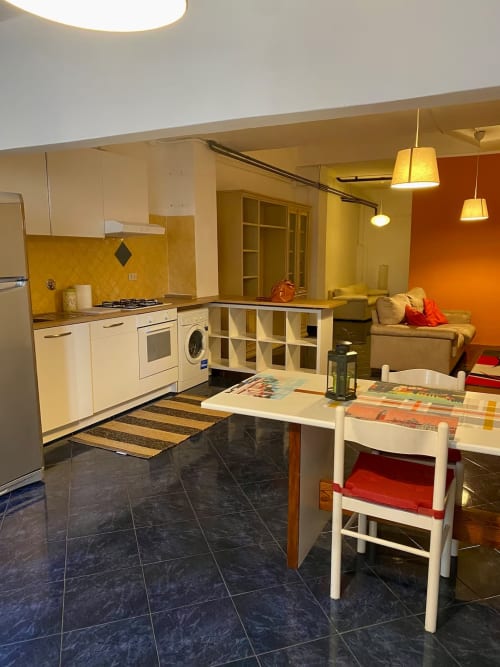Cucina e zona pranzo moderna del B&B Fossatello a Genova con alzatile gialla e vista sulla città