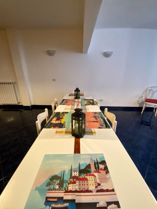Zona pranzo moderna in appartamento a Genova con opere d'arte a tema di viaggi italiani e lanterna centrale