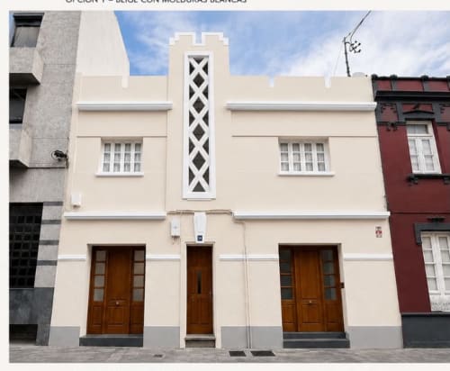 Fachada de edificio Art Déco color beige en Santa Cruz de Tenerife con puertas de madera y molduras blancas
