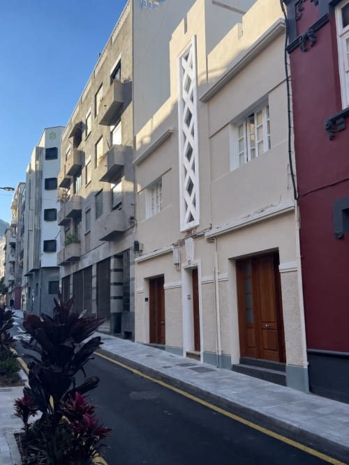 Calle histórica en Santa Cruz de Tenerife con arquitectura colonial, edificios coloridos y puertas de madera