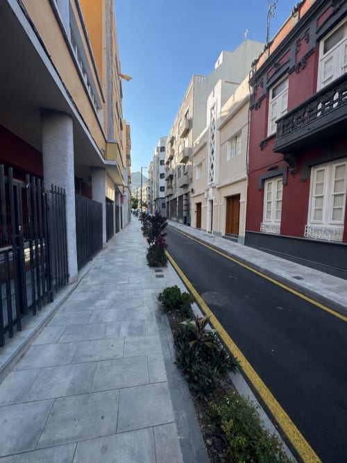Estrecha calle peatonal en Santa Cruz de Tenerife con coloridas casas coloniales y marcas amarillas en el camino