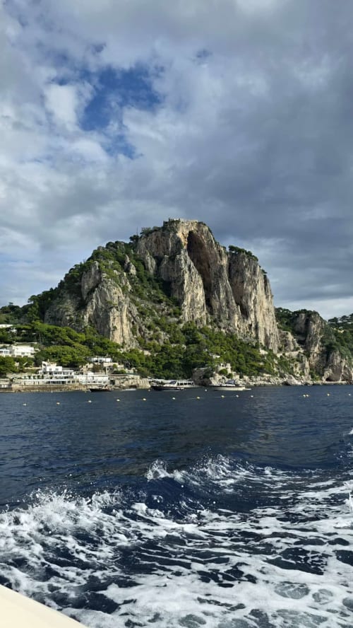 Scogliera rocciosa di calcare si erge dal mare a Meta di Sorrento con l'hotel Relais Palazzo Cacace sottostante