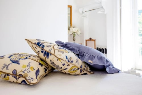 Cuscini decorativi su letto nella luminosa camera da letto di Villa Palazzo Cacace a Meta di Sorrento con vista sul giardino