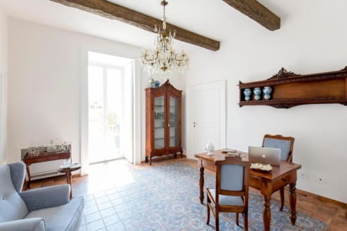 Elegante camera al Relais Palazzo Cacace a Meta di Sorrento con arredamenti in legno, lampadario di cristallo e vista sul giardino