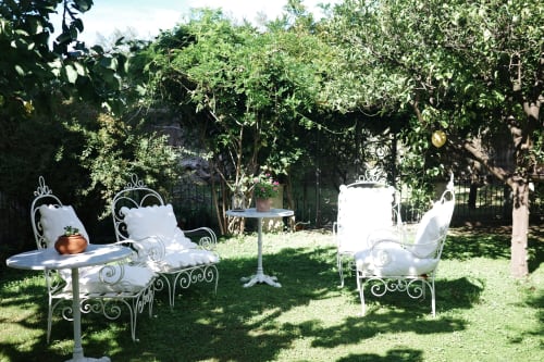 Elegante arredamento in ferro battuto bianco in rigoglioso giardino presso il Relais Palazzo Cacace, Meta di Sorrento