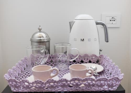 Elegante servizio da tè al Relais Palazzo Cacace con bollitore SMEG, tazze e tovaglia di pizzo viola