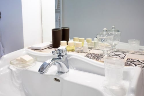 Lussuoso lavabo con rubinetto cromato, accessori e articoli da toeletta presso il cottage Relais Palazzo Cacace a Meta di Sorrento