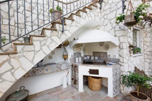 Cucina mediterranea all'aperto con soffitto ad arco, piastrelle decorative e cortile in pietra presso Relais Palazzo Cacace, Meta di