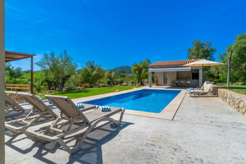 Villa de lujo con piscina en Artà, tumbonas, casa de piscina moderna, jardines cuidados y vistas a la montaña