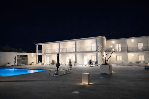 Villa moderna a Ortona di notte con facciata bianca illuminata, terrazza con piscina e arredamento contemporaneo