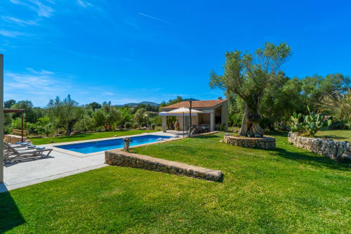 Villa de lujo en Artà con piscina, jardín cuidado y arquitectura mediterránea rodeada de olivos