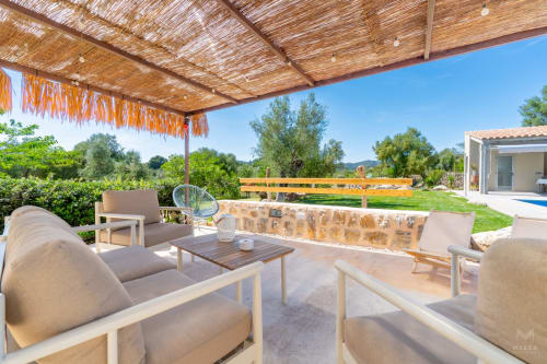 Patio sombreado con zona de descanso en el hotel Massa Properties de Artà, España