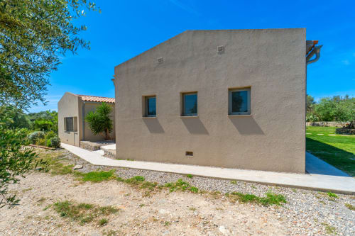 Villa moderna de tonos beige con piscina en Artà, España, diseño minimalista y jardines paisajísticos