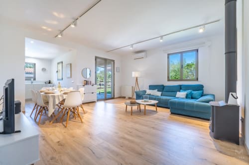 Moderno apartamento diáfano en Artà con sofá azul, comedor, suelo de madera y acceso a terraza