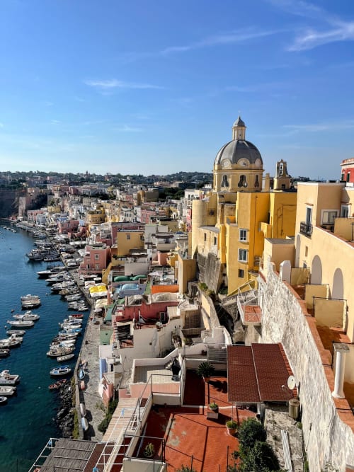 Affascinante borgo costiero Il Poeta a Procida con chiesa dalla cupola gialla e barche colorate nel suggestivo porto