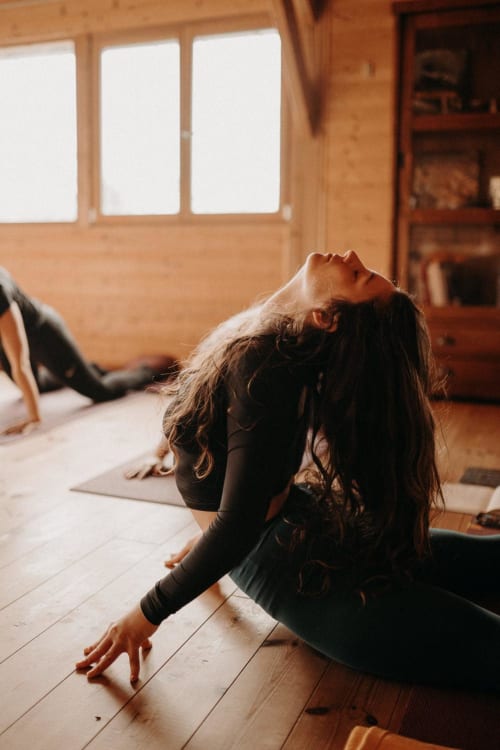 Woman doing yoga in bright wooden studio at Le Petit Château De Conteville, Paluel France B&B