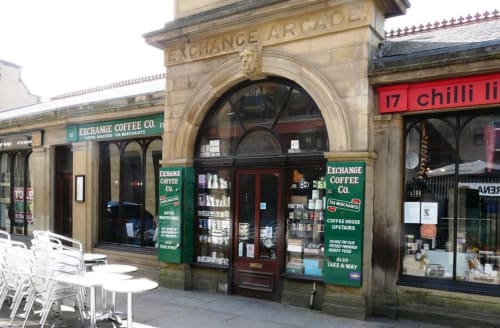 Exchange Coffee Co storefront on Blackburn street with green signage, arched entrance, and outdoor seating