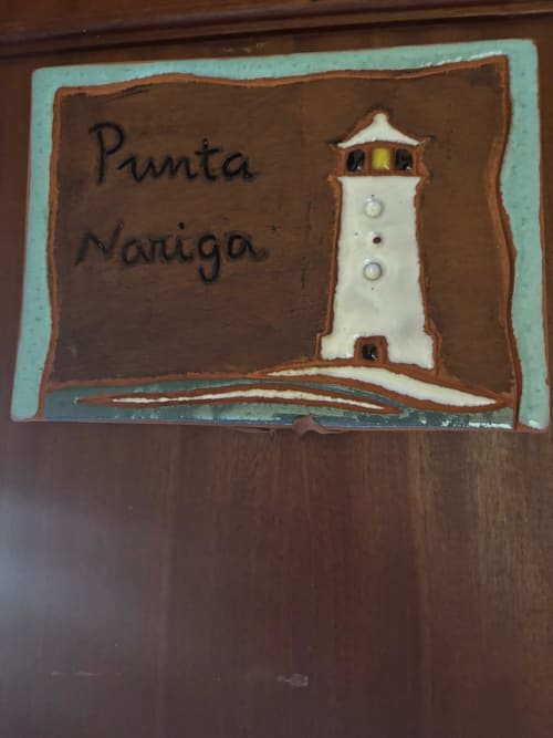 Letrero de habitación Punta Nariga en Hotel Restaurante O Esqueiro en Malpica, A Coruña, con ilustración de faro en madera