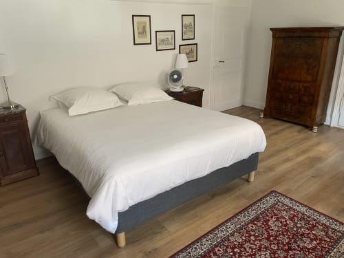Spacious bedroom at Ferme Freysz B&B in Quatzenheim with queen bed, white linens, wooden furniture, and garden view.