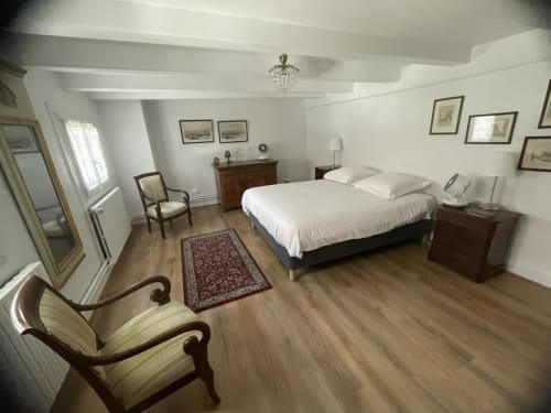 Spacious bedroom at Ferme Freysz B&B in Quatzenheim with double bed, wooden furniture, sitting area, and garden view