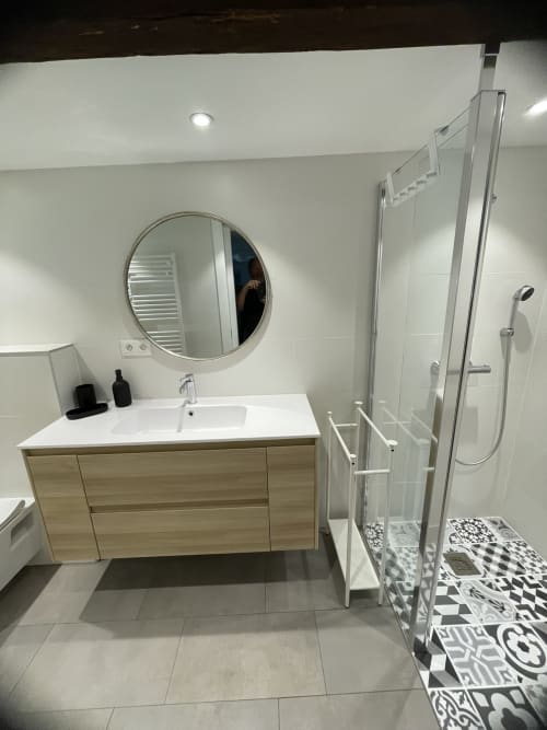 Modern bathroom with wooden vanity, round mirror, and walk-in shower at Ferme Freysz bed and breakfast in Quatzenheim, France