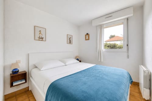 Chambre lumineuse avec literie blanche, plaid bleu et vue sur la mer à La Loge Du Bassin, Lège-Cap-Ferret